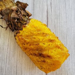 Grilled and smoked pineapple on wood background